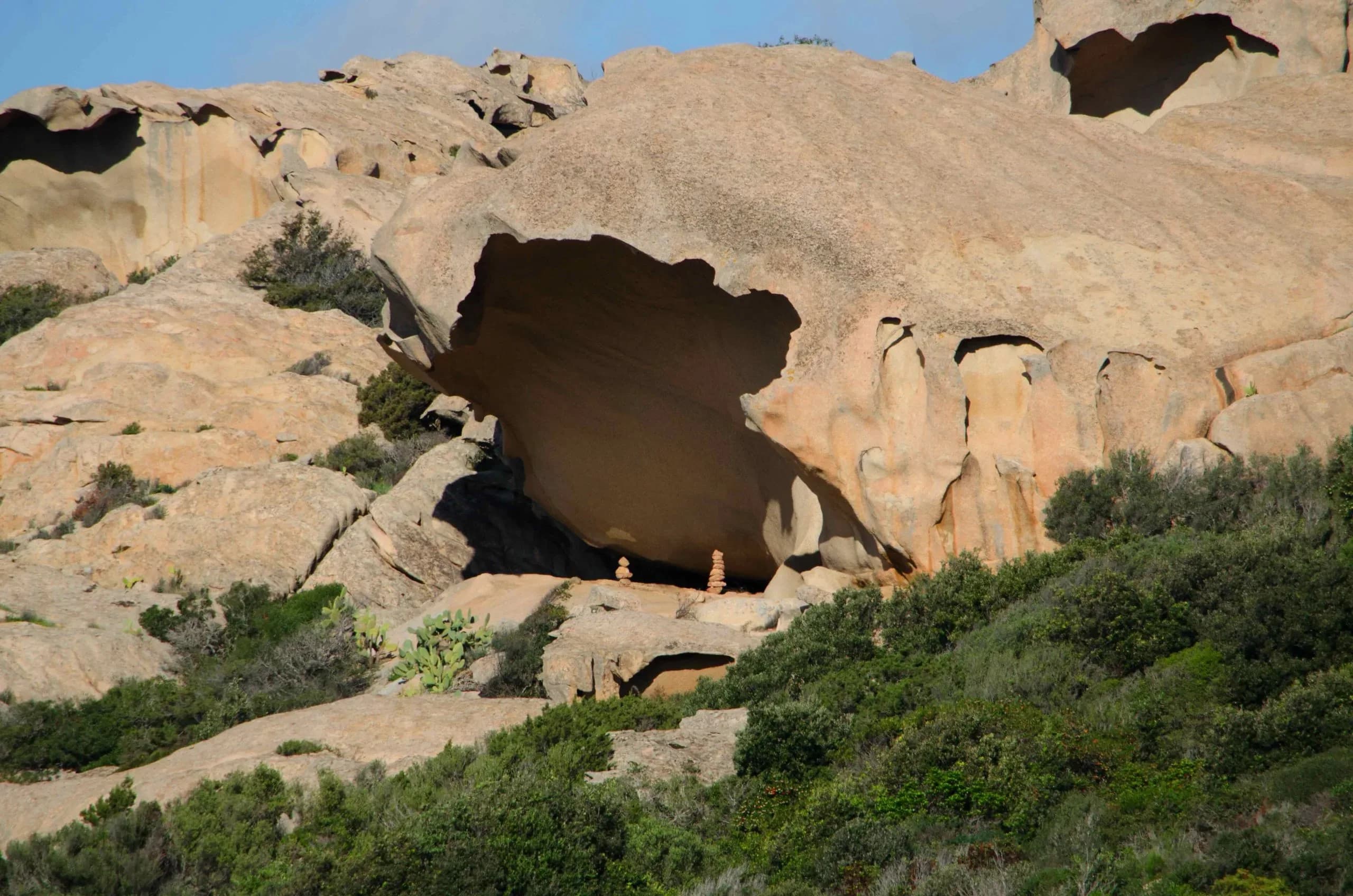 Große Felsformation mit Höhle und grüner Vegetation