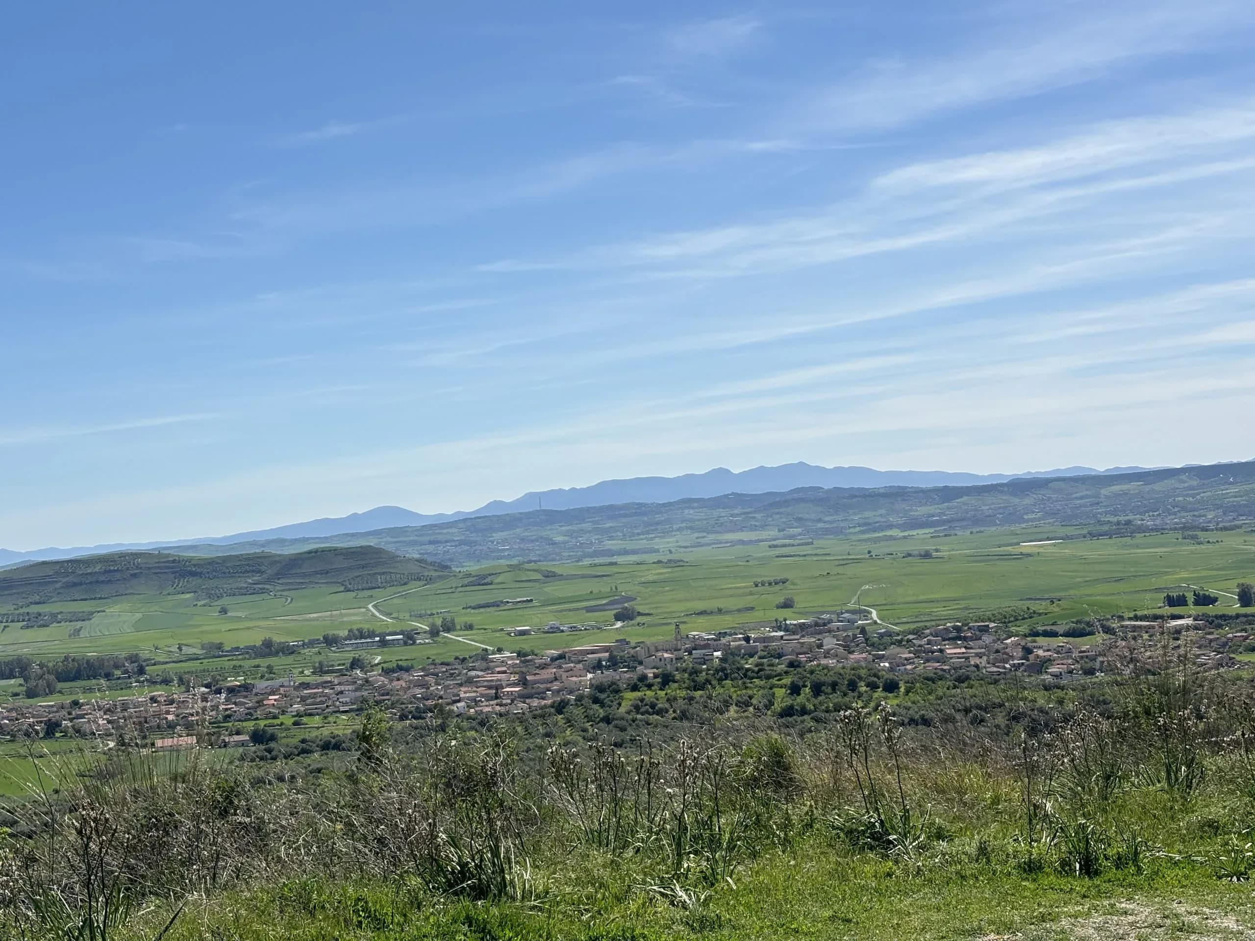 Green valley with village and distant mountains