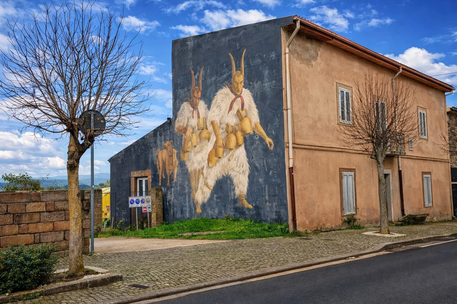 Straßenszene mit Wandmalerei kostümierter Figuren