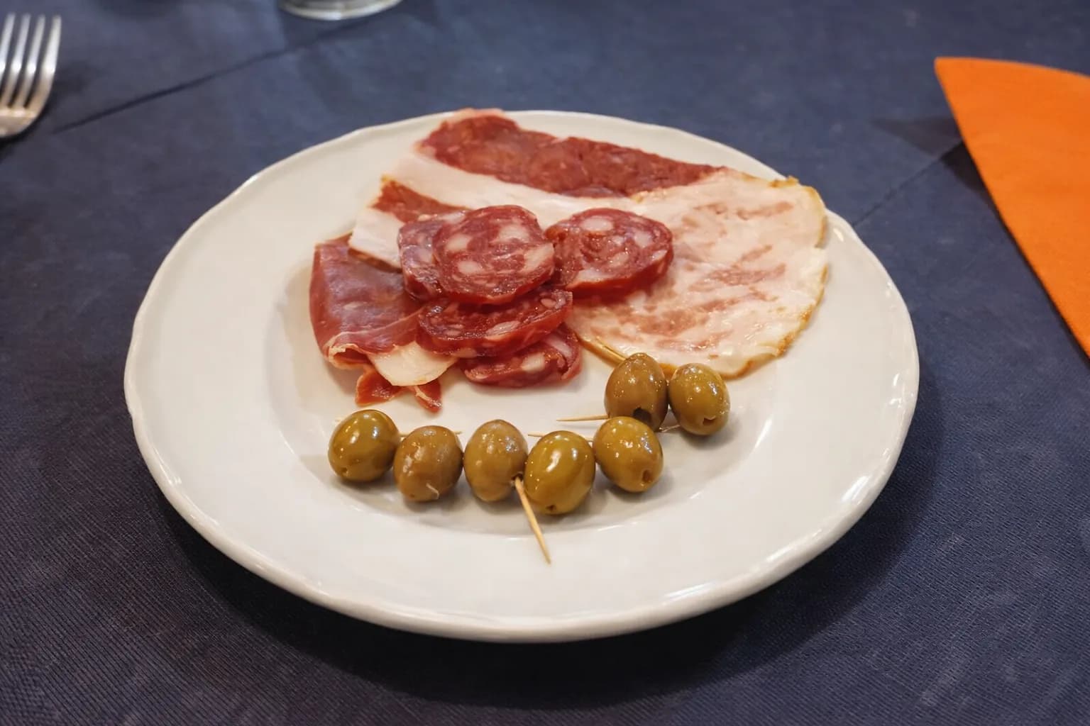 Vorspeisenteller mit Fleisch und Oliven.