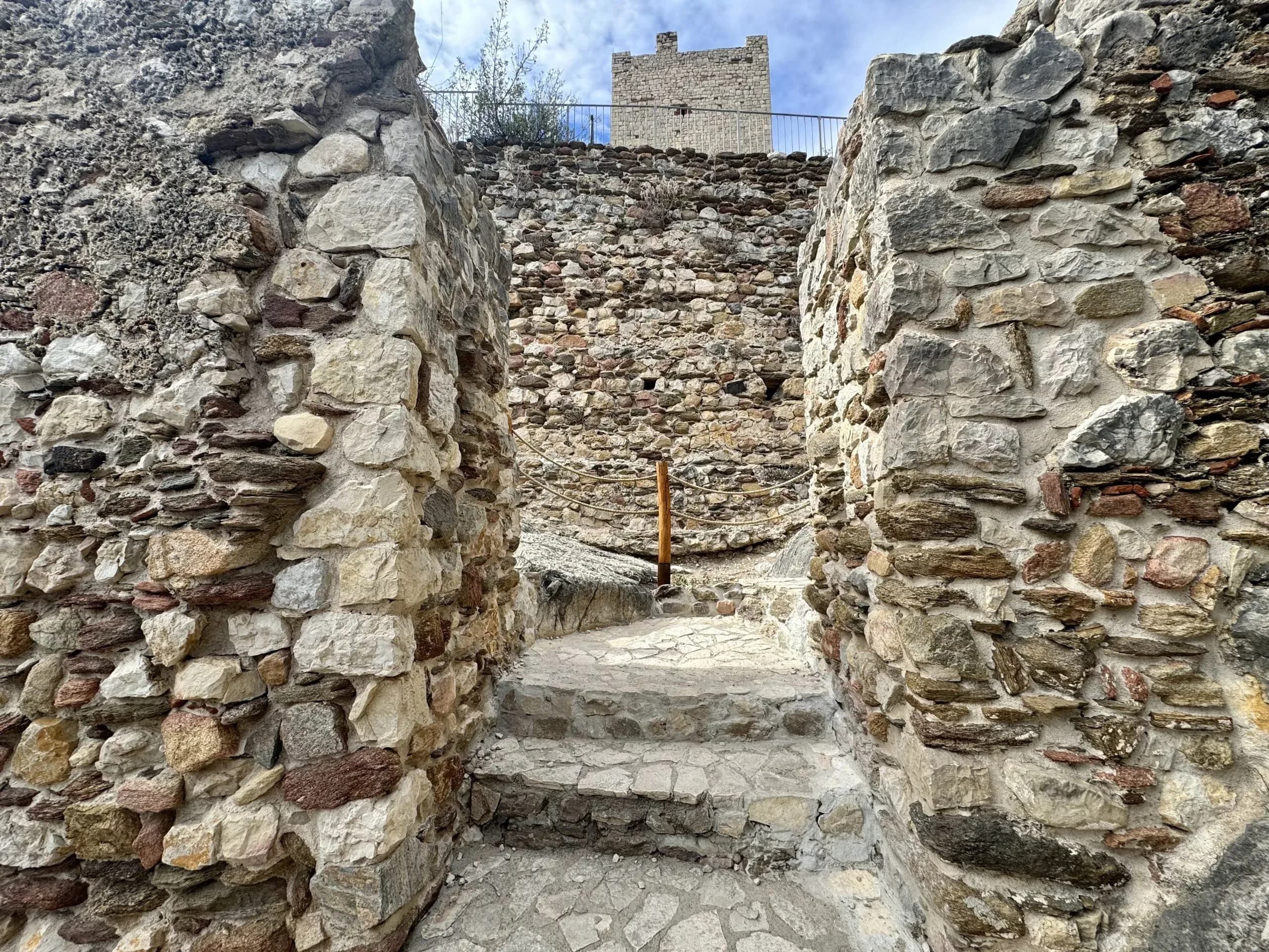 Steinstufen führen zu einer Burgruine hinauf.