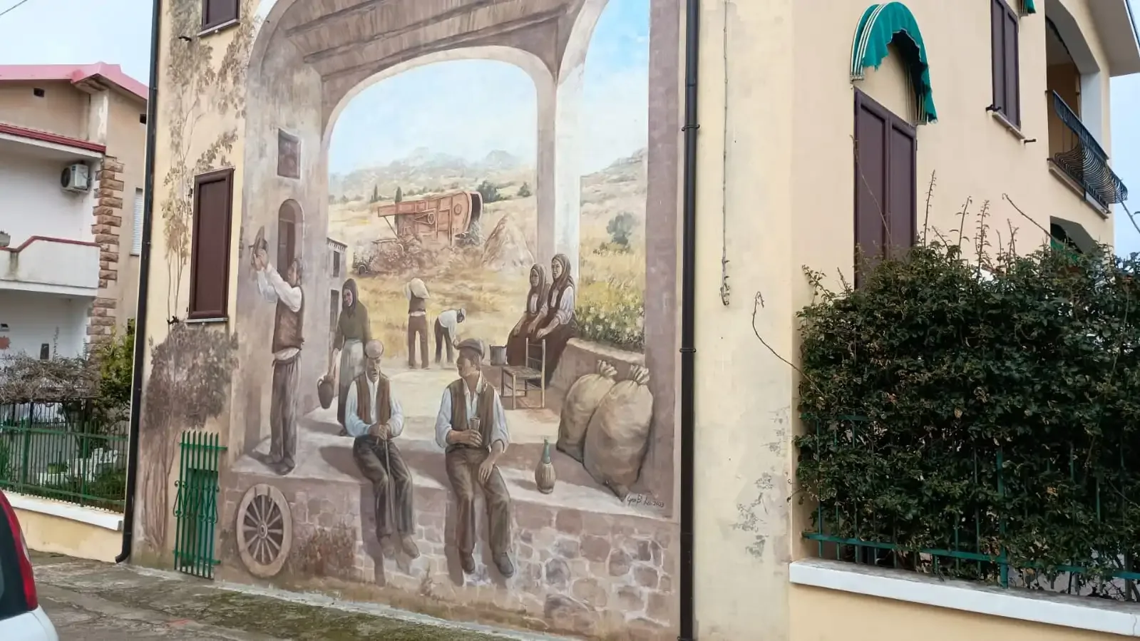 Mural depicting rural life on a building.