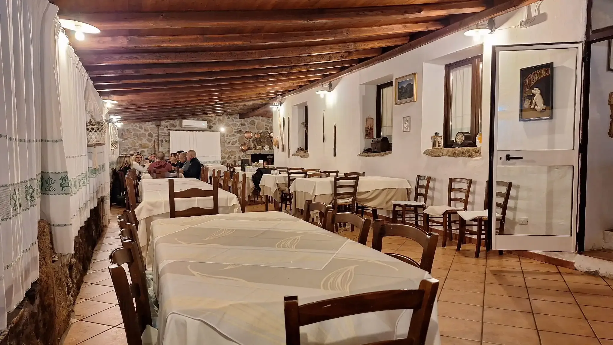 Restaurantinterieur met tafels en dinerende mensen.