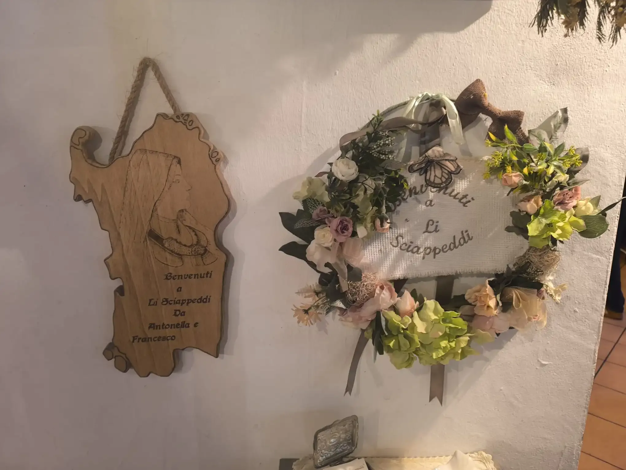 Houten welkomstbord met bloemenkrans decoratie.