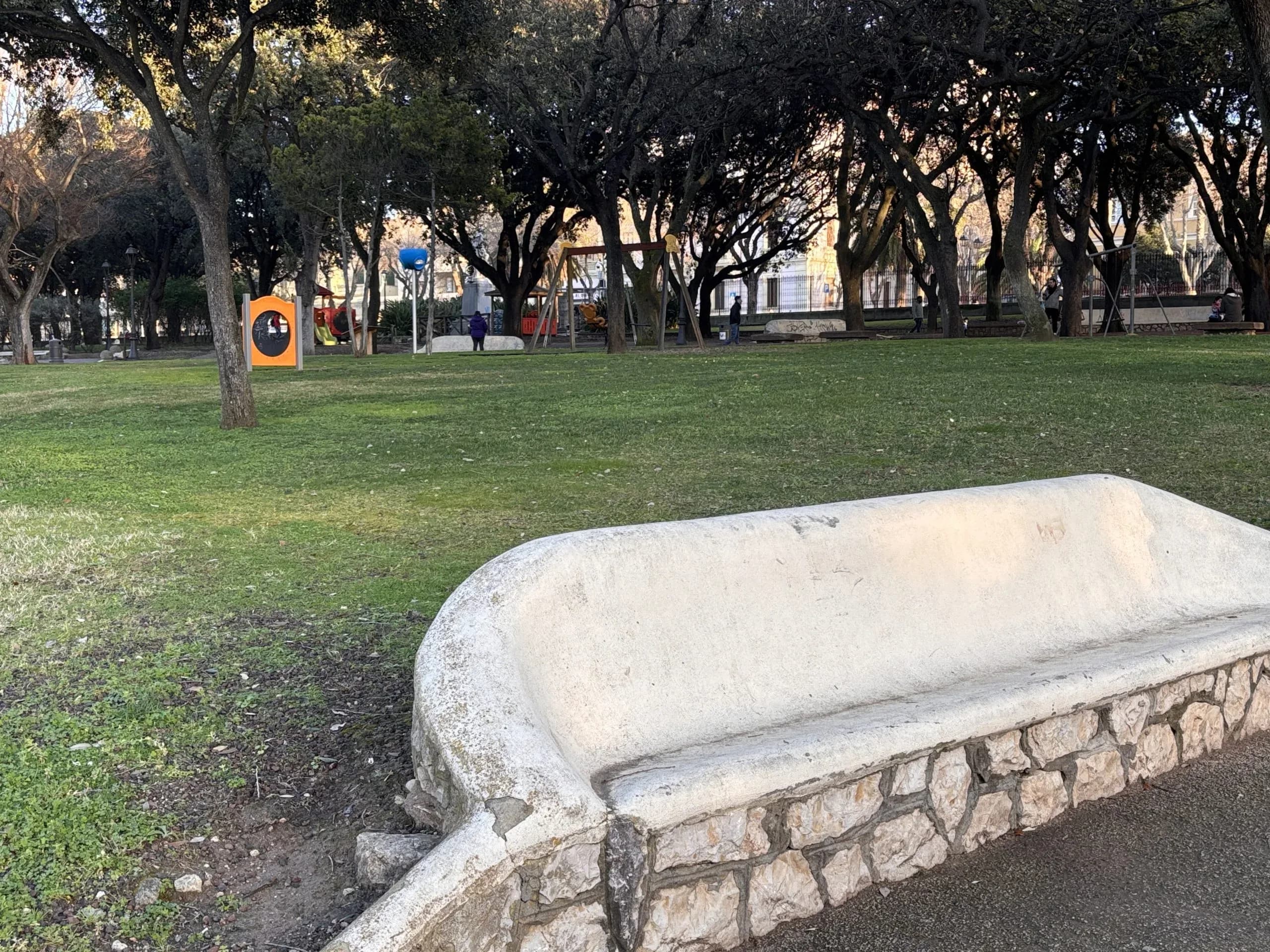 Banc de parc avec aire de jeux en arrière-plan.