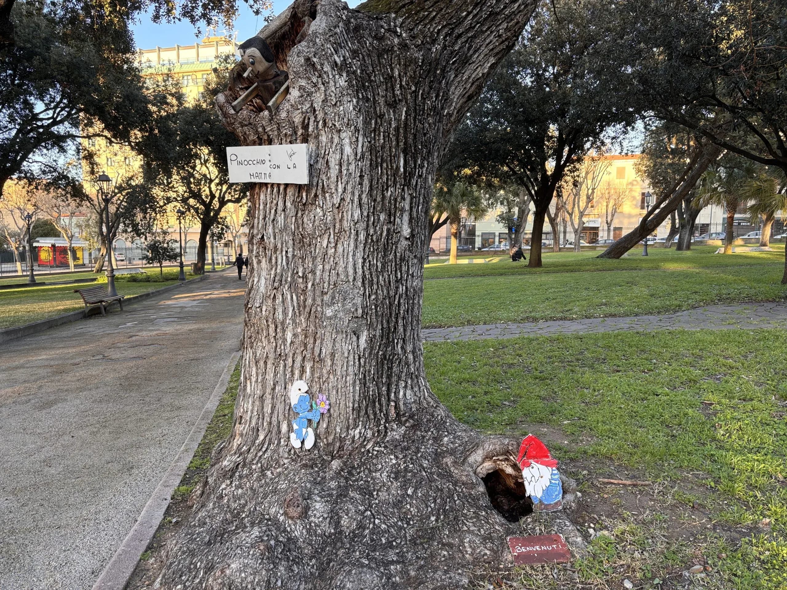 Arbre décoré dans un parc avec Pinocchio et un Schtroumpf.