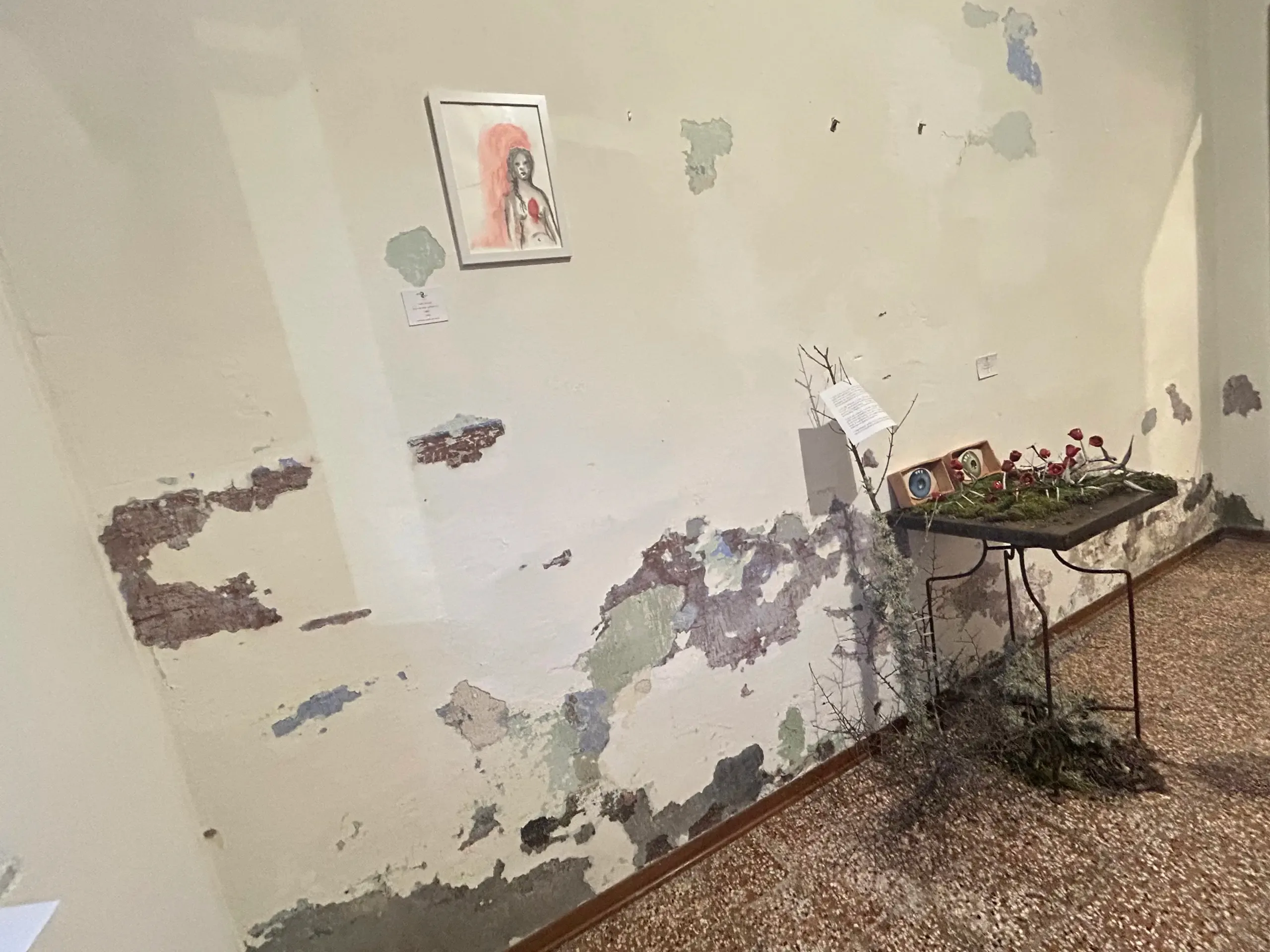 Kunstinstallation in einem Raum mit abblätternden Wänden.
