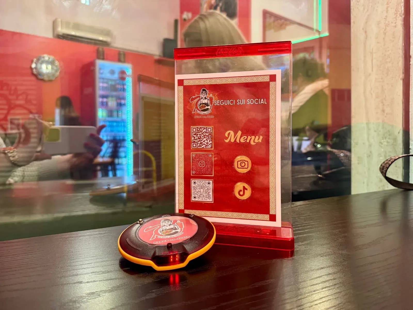 Restaurant table with pager and menu sign.