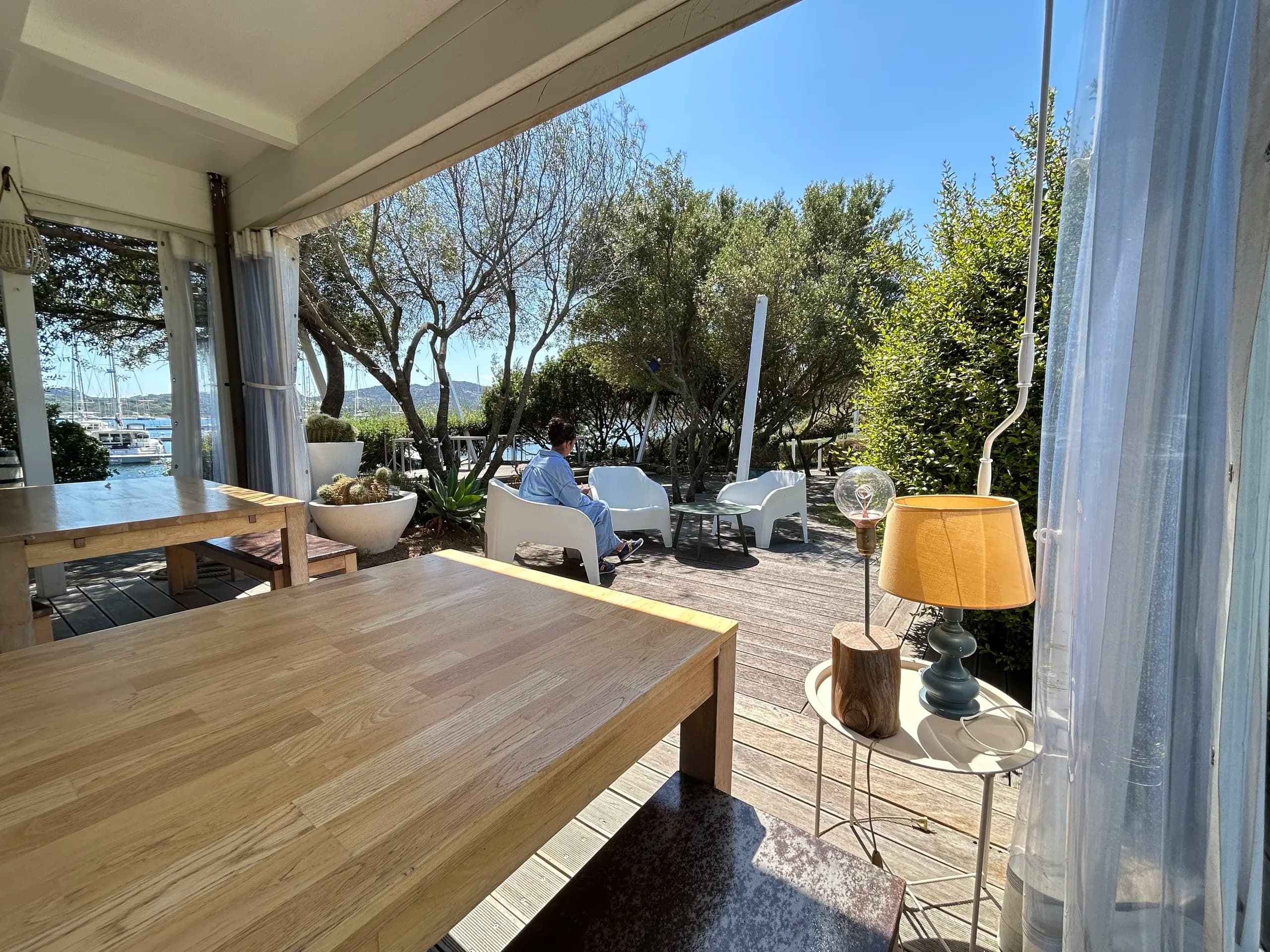 Zonnig terras aan het water met zitplaatsen en uitzicht op de jachthaven