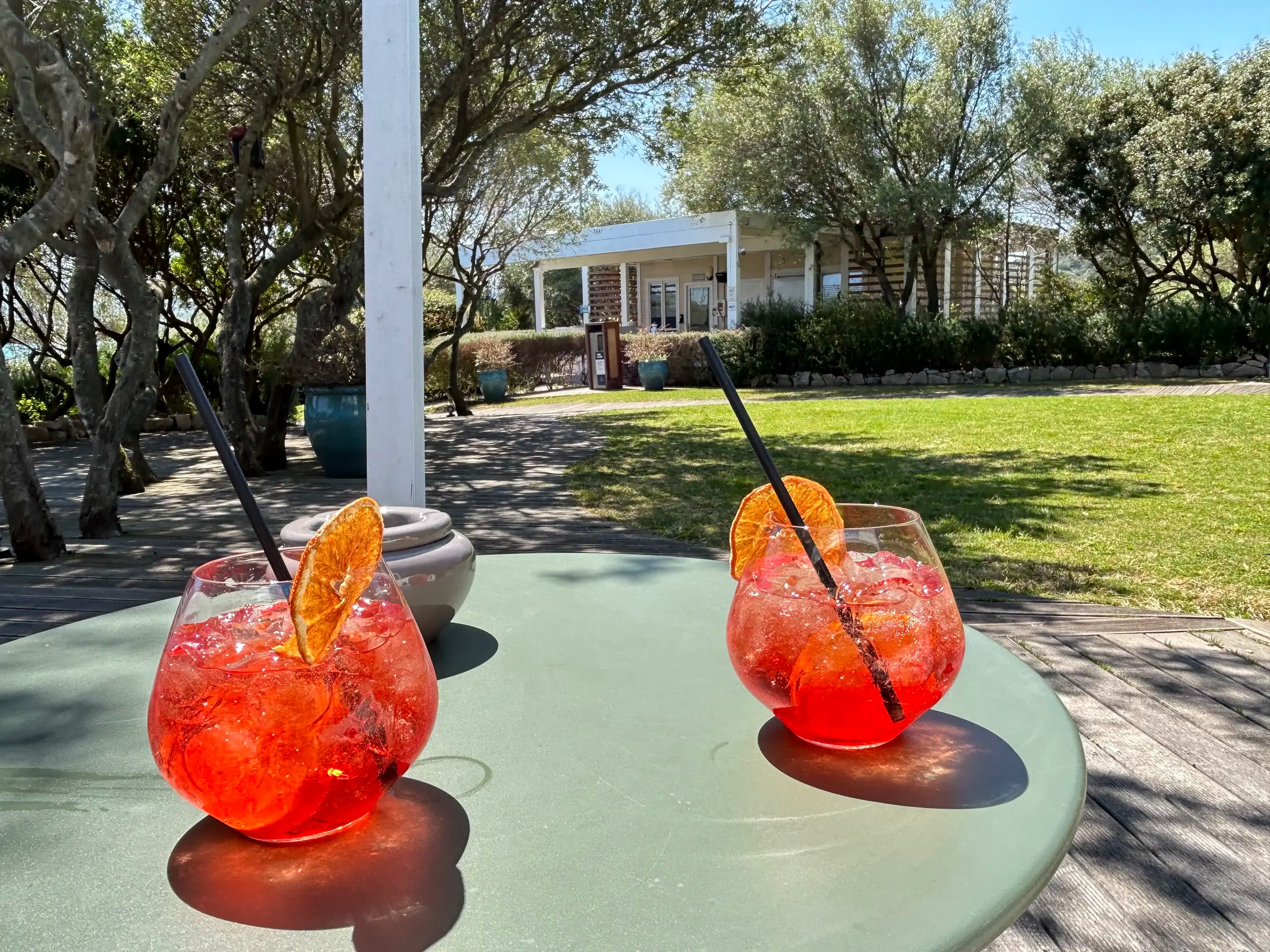 Twee rode cocktails op een zonnig tuintafeltje