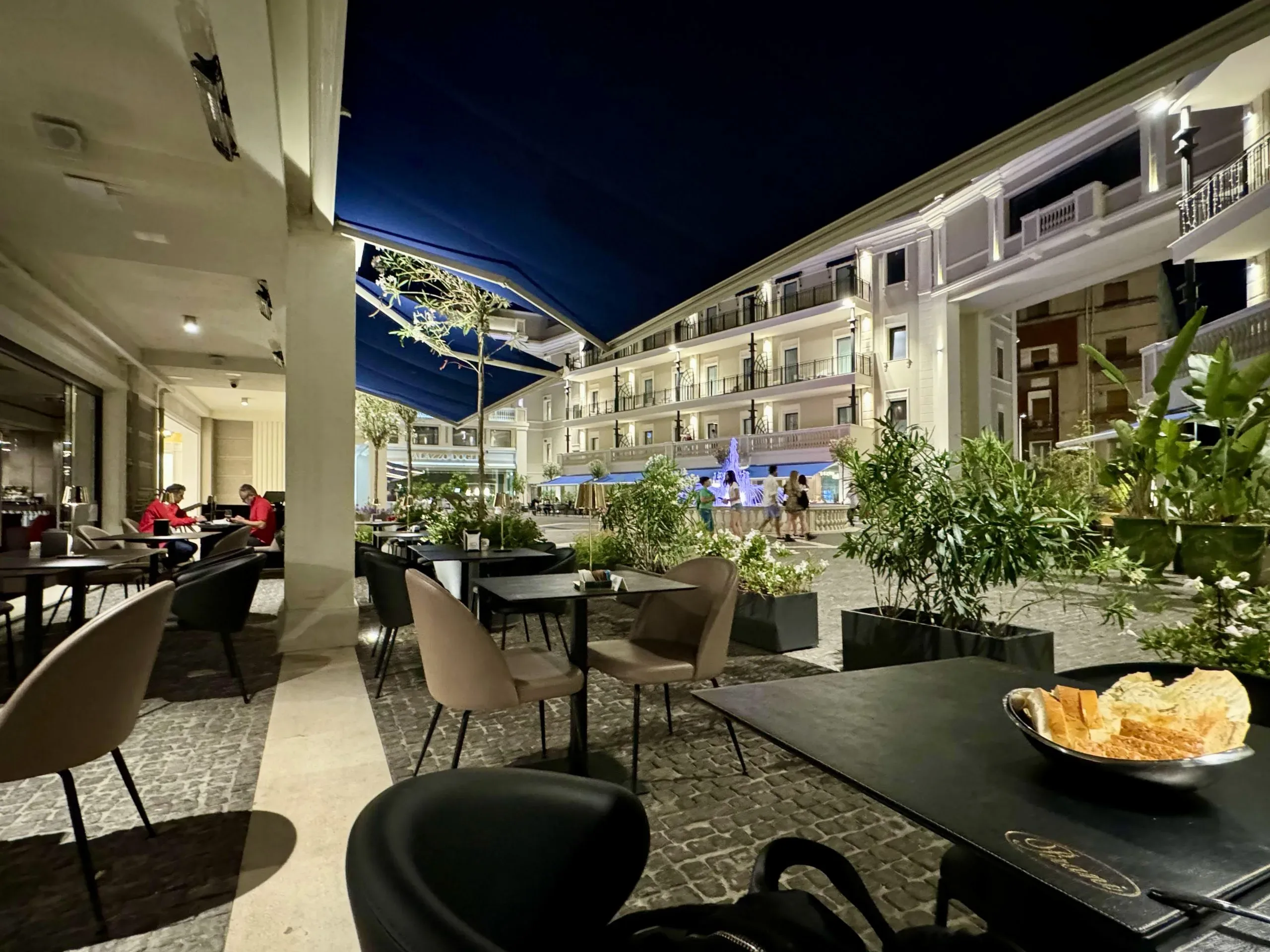 Outdoor restaurant at night in European city.