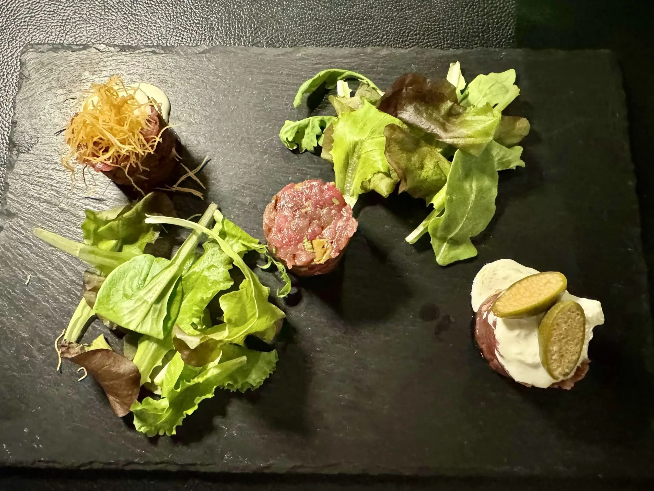 Beef tartare with salad on slate plate