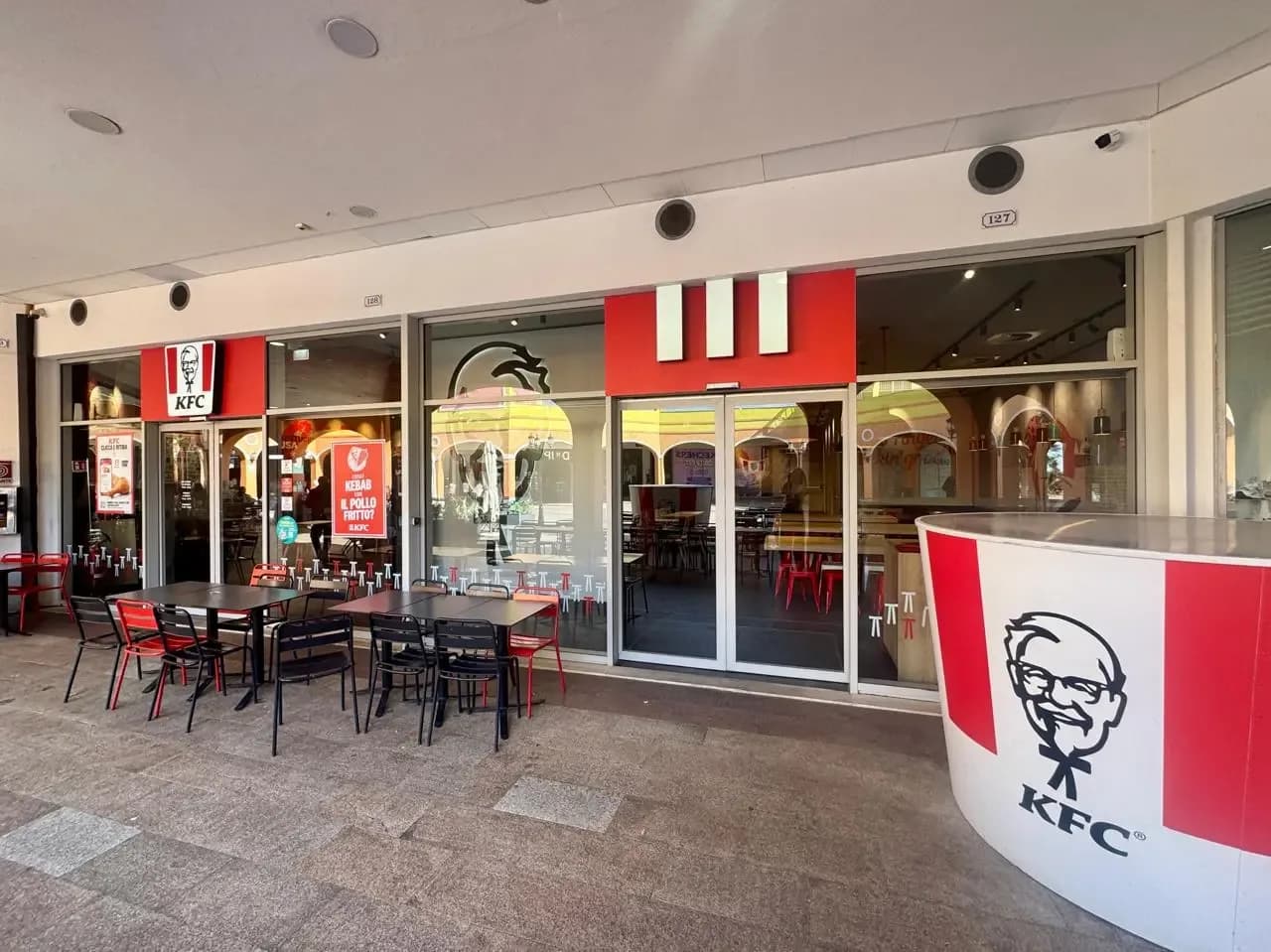 KFC restaurant exterior with tables and chairs.