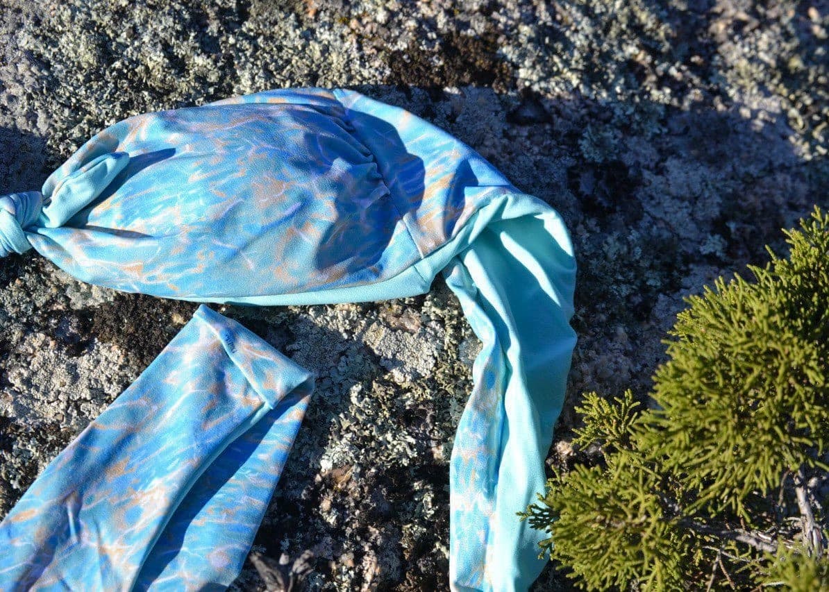 Blue patterned scarf on rocky ground outdoors