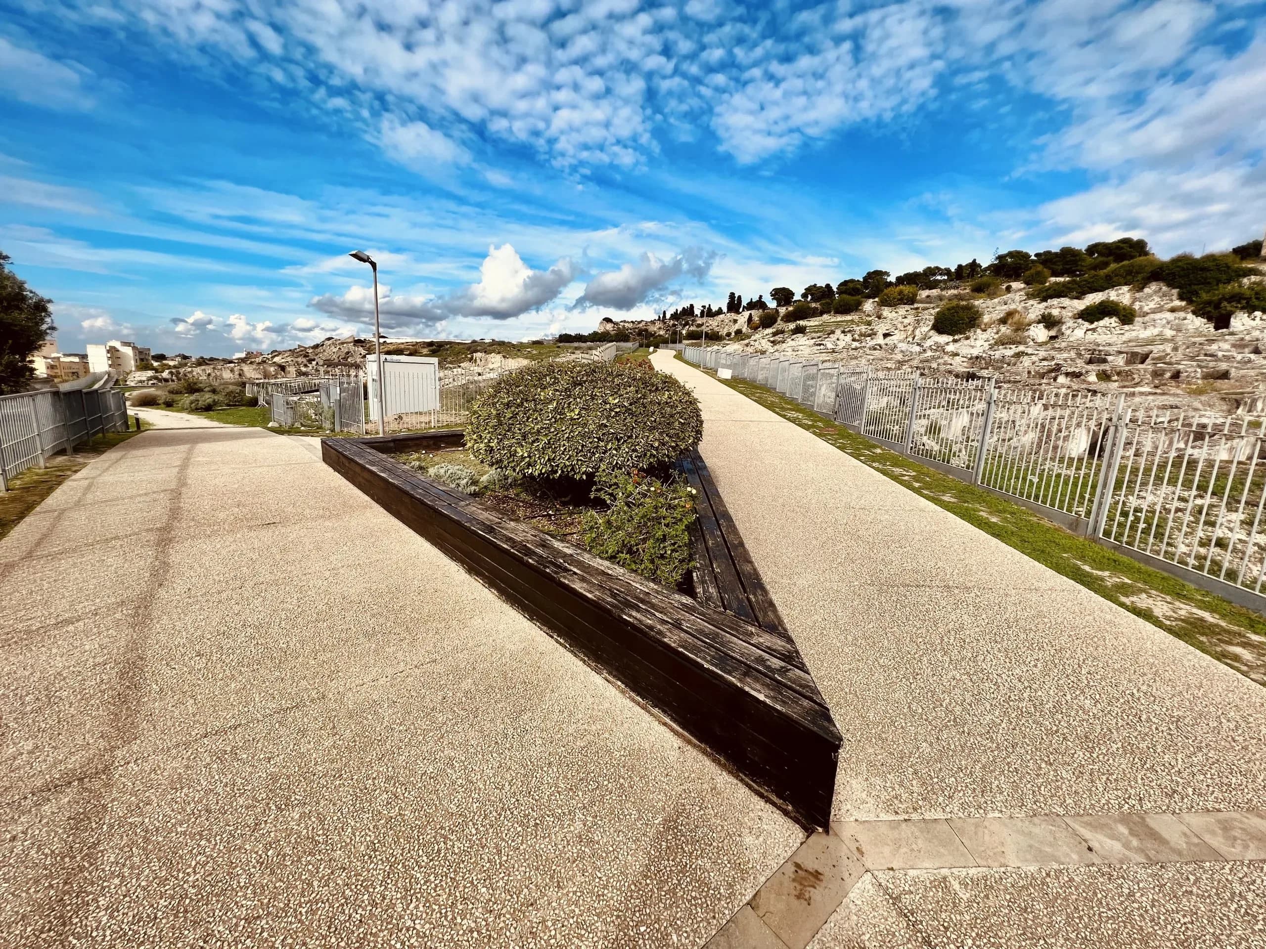 Path with stone ruins and a cloudy blue sky.