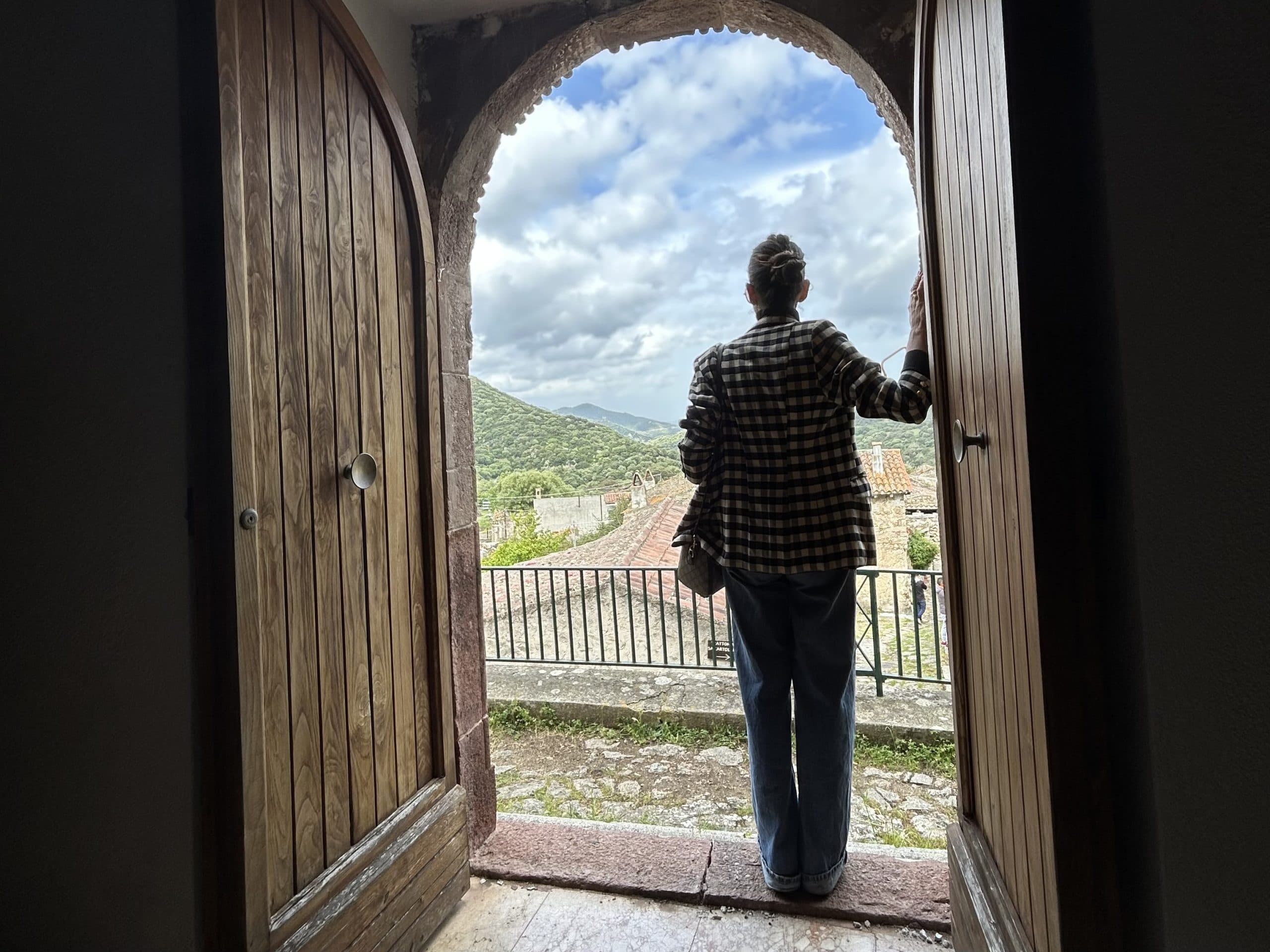 Personne dans l'embrasure d'une porte surplombant un village de montagne