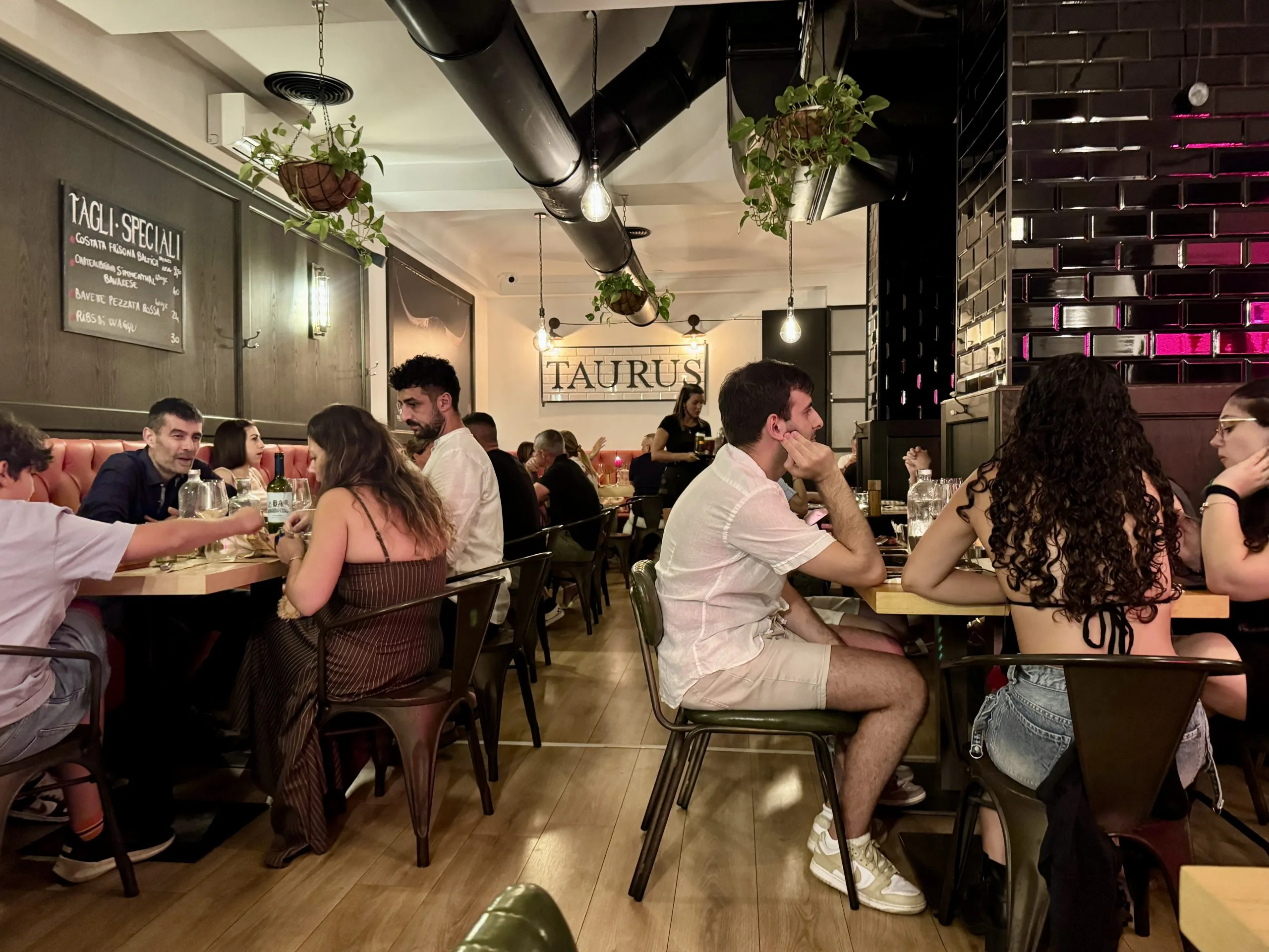 Moderno ristorante affollato con commensali e piante pensili