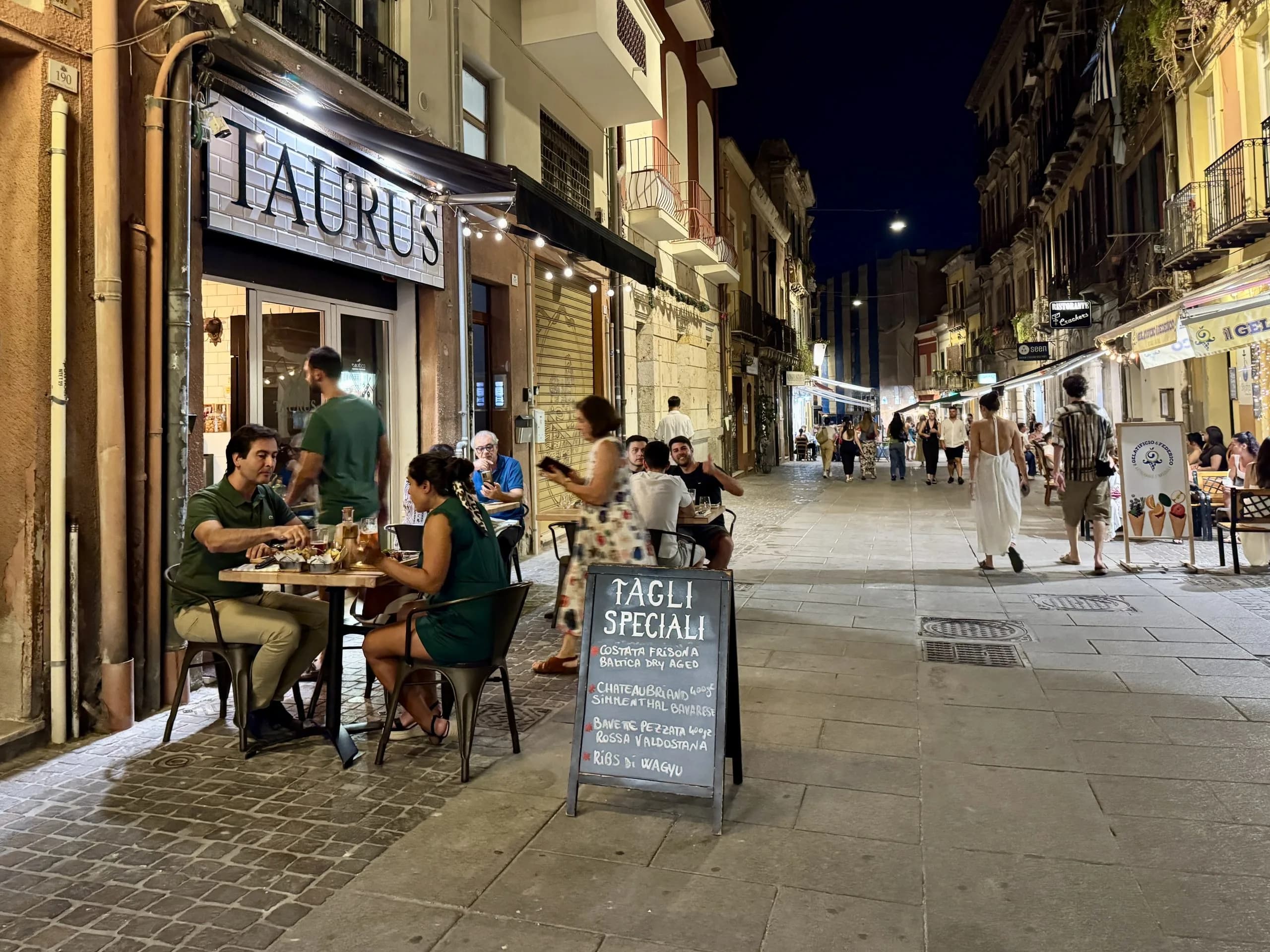 Outdoor dining on lively Italian street at night