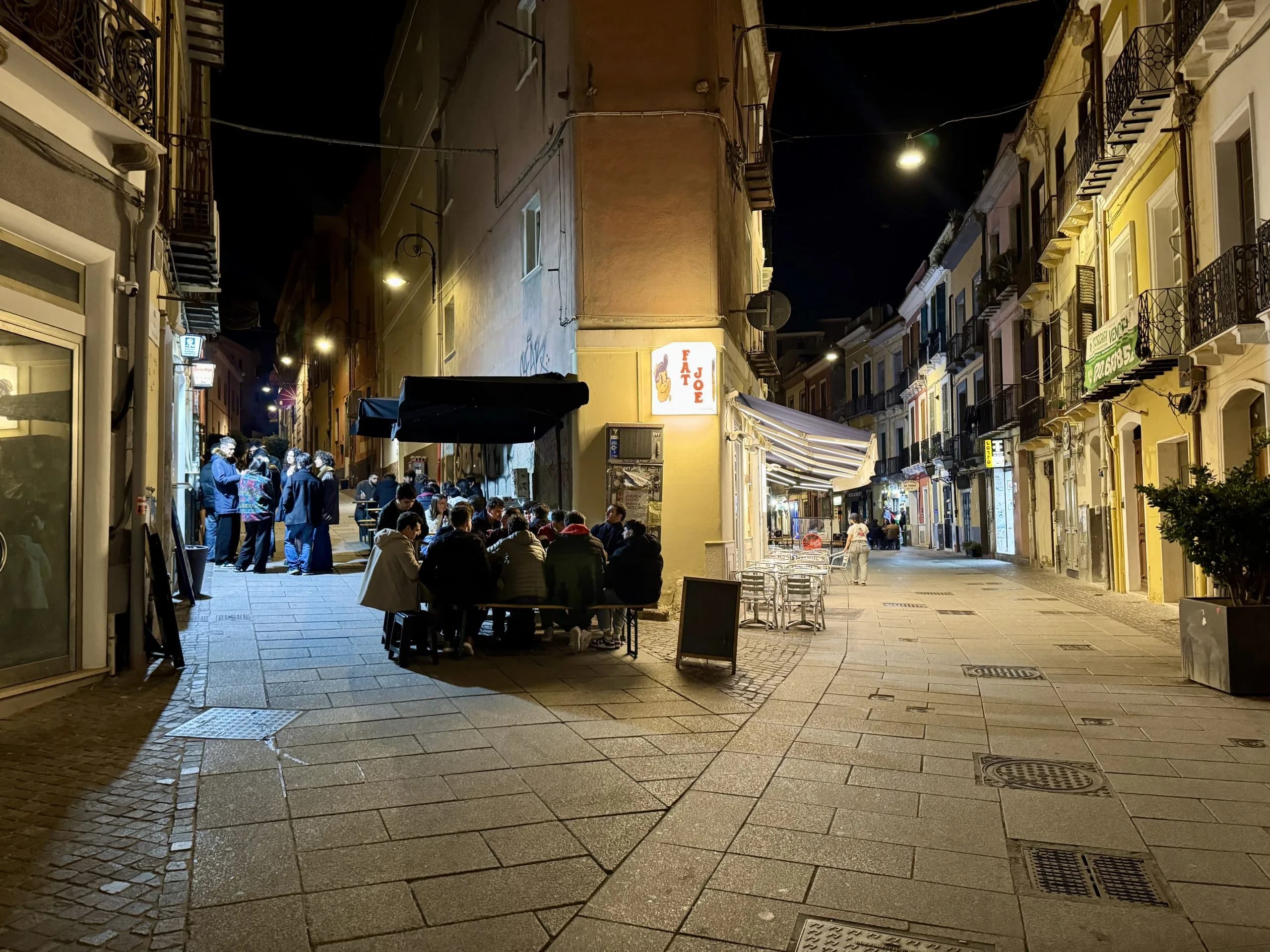Outdoor diners on narrow street at night