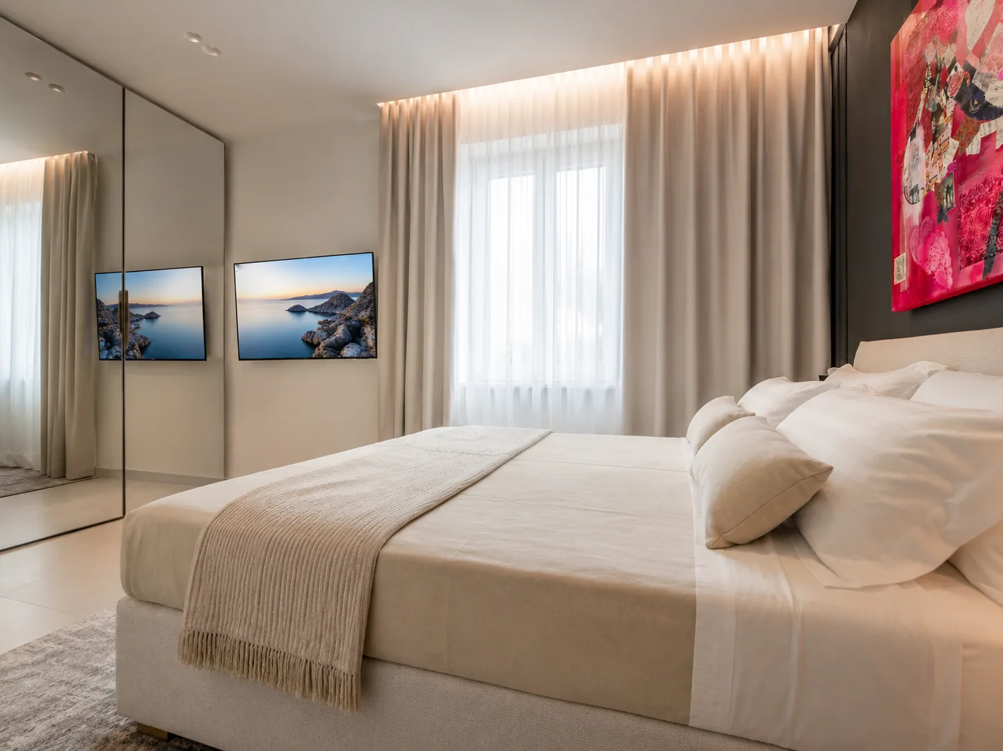 Camera da letto moderna con biancheria color crema, grande specchio, opere d'arte con paesaggi costieri alle pareti, tende a tutta altezza e pannello d'arte astratta rossa nell'appartamento con giardino di AZULIS DelleTerme Suites, Olbia
