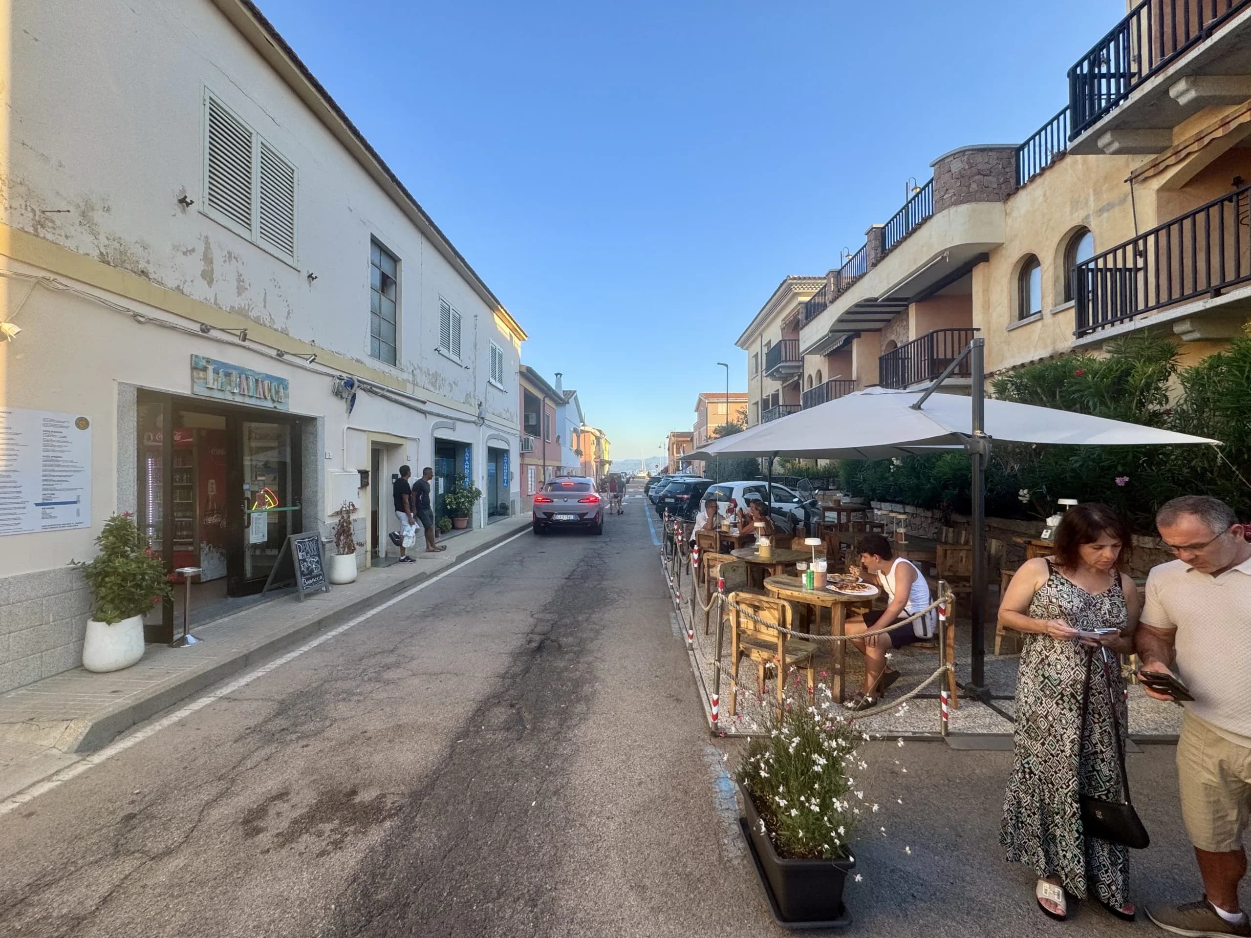 Tavolini di un caffè all'aperto lungo una stretta via europea