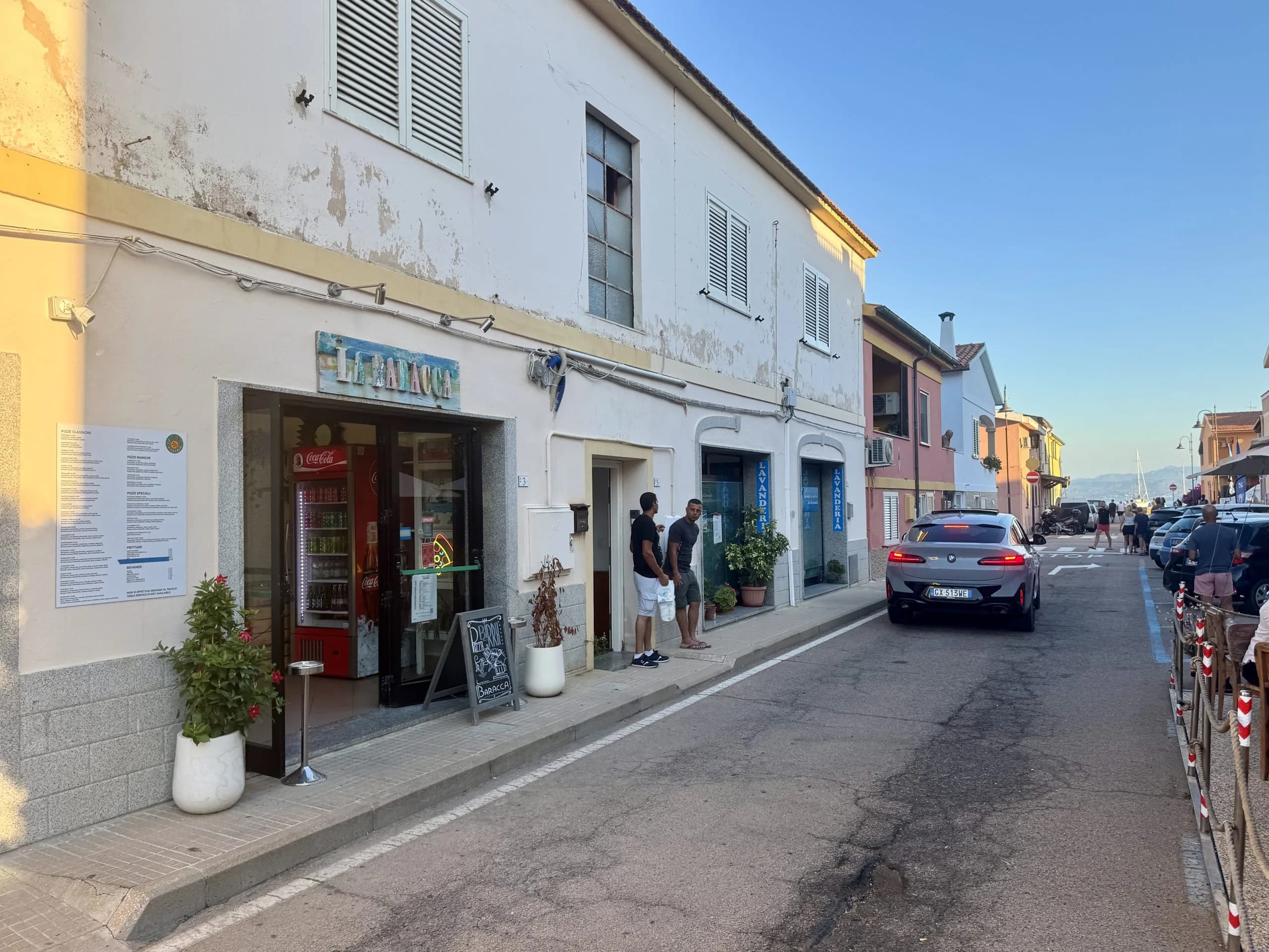 Piccola pizzeria su una tranquilla via costiera al tramonto