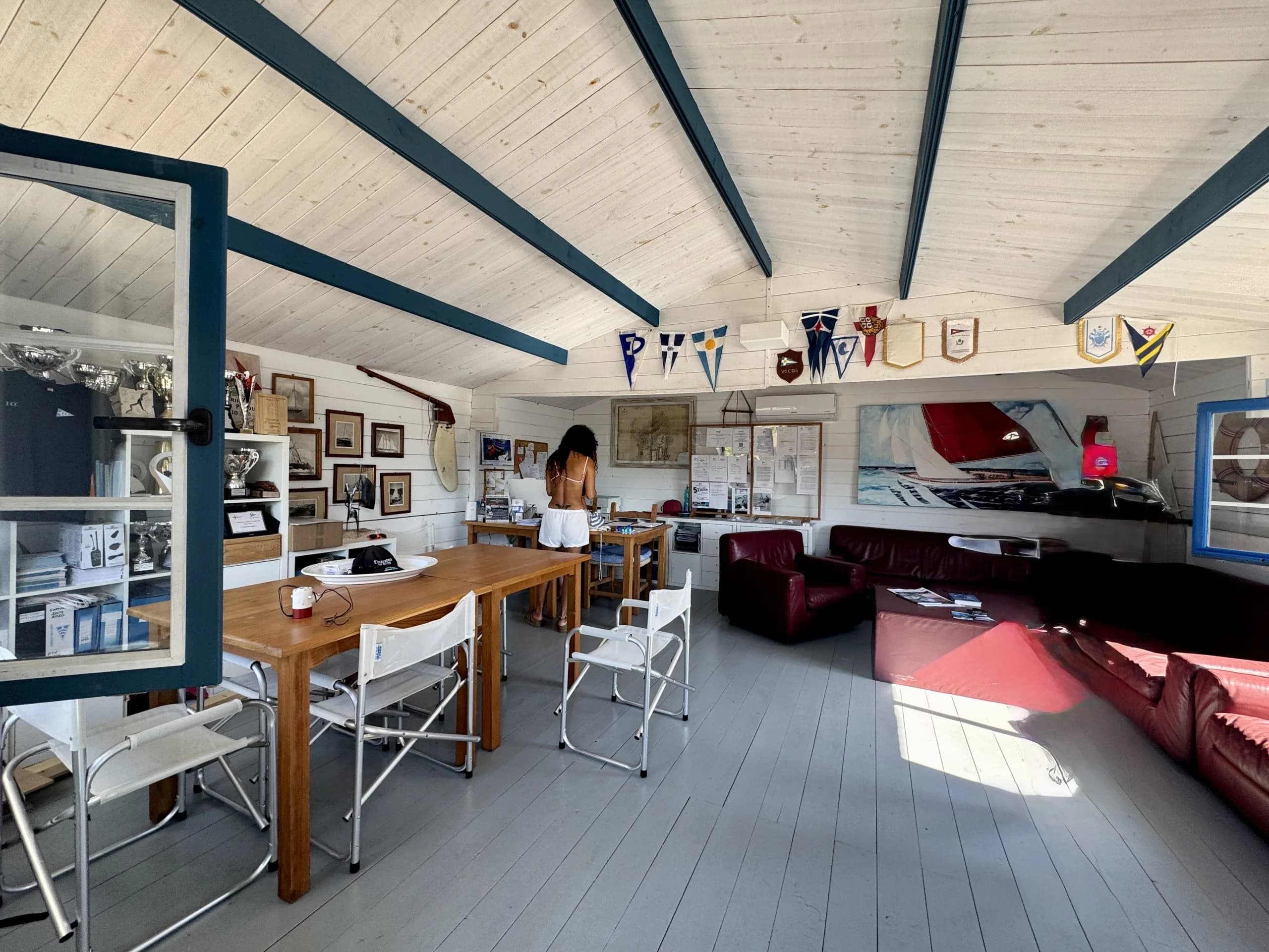 Nautical clubhouse interior with trophies and sailboat painting