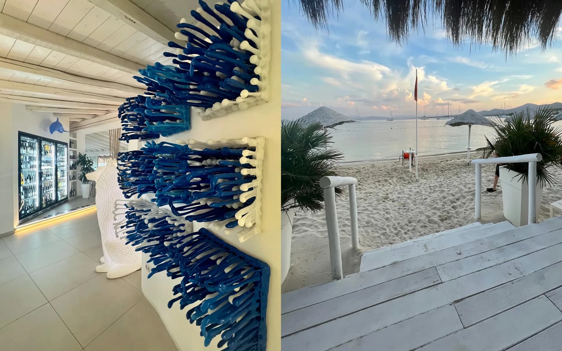Immagine divisa: l'interno bianco di un ristorante in spiaggia con sculture da parete blu simili a coralli e una cantinetta illuminata, e gradini bianchi che scendono a una spiaggia sabbiosa al crepuscolo con ombrelloni di paglia e barche ormeggiate.