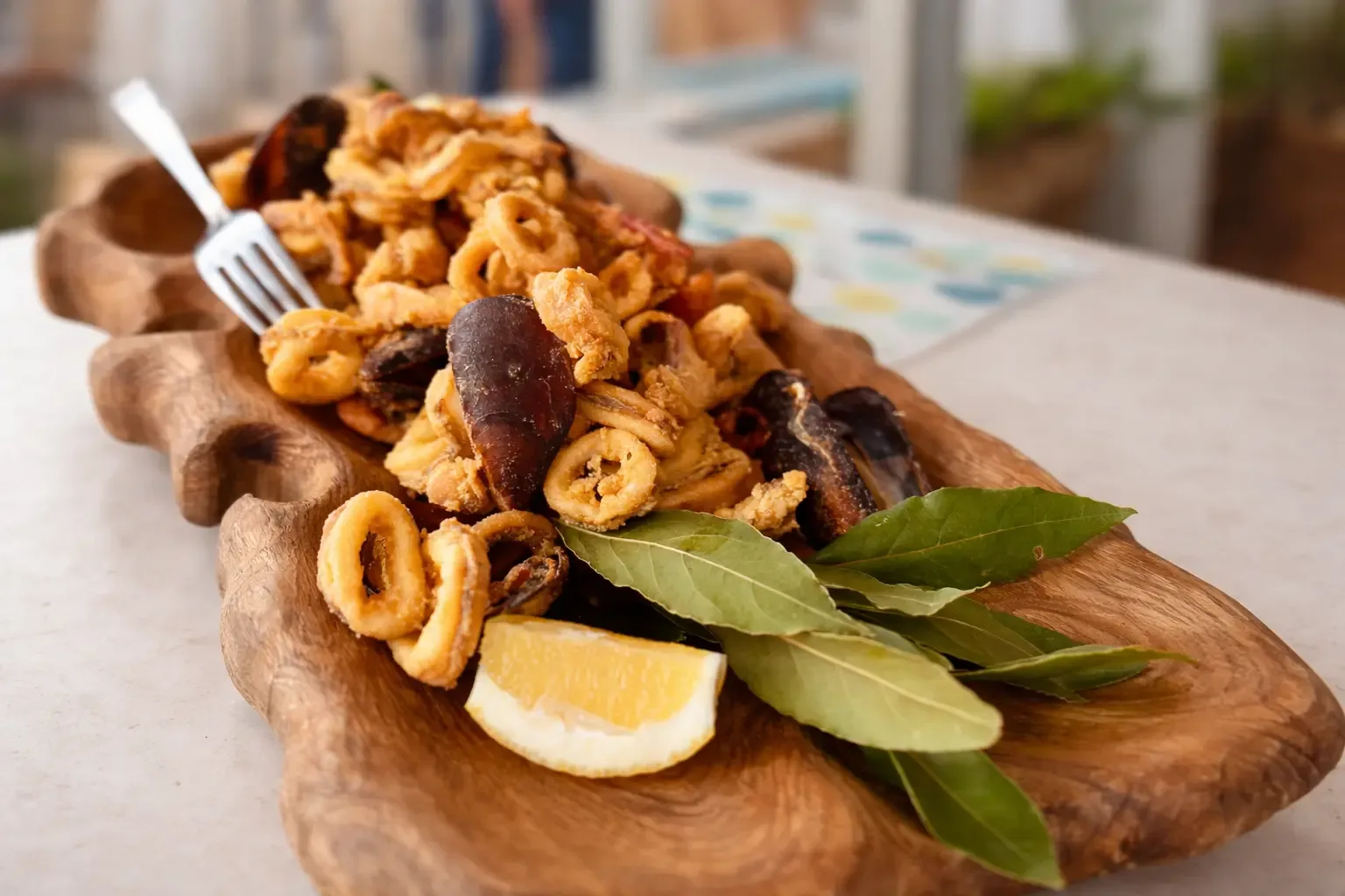 Fried calamari and mussels on wooden platter
