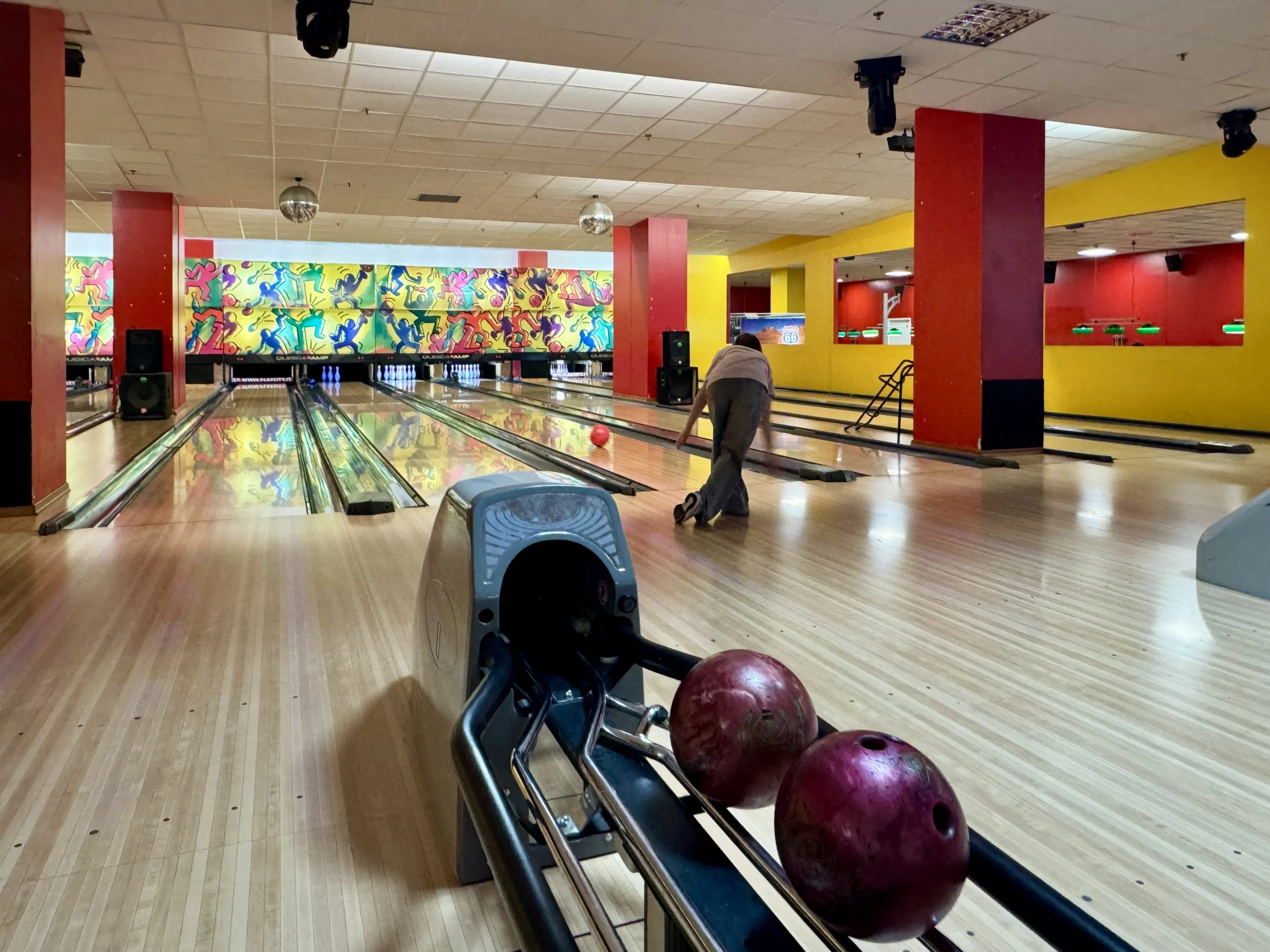 Person bowling in colorful indoor bowling alley